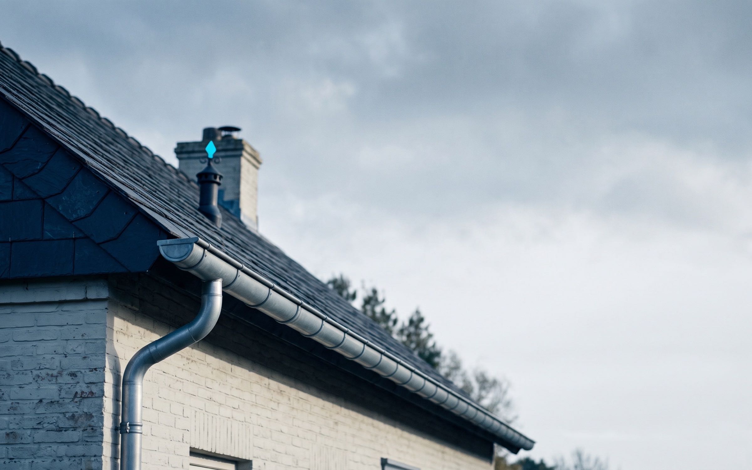 Plano general de un techo y una canaleta de una casa bajo un cielo nublado.
